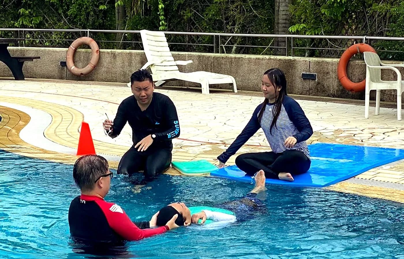 Penguin Academy practical swim teacher assessment with a candidate learning poolside coaching and rescue support