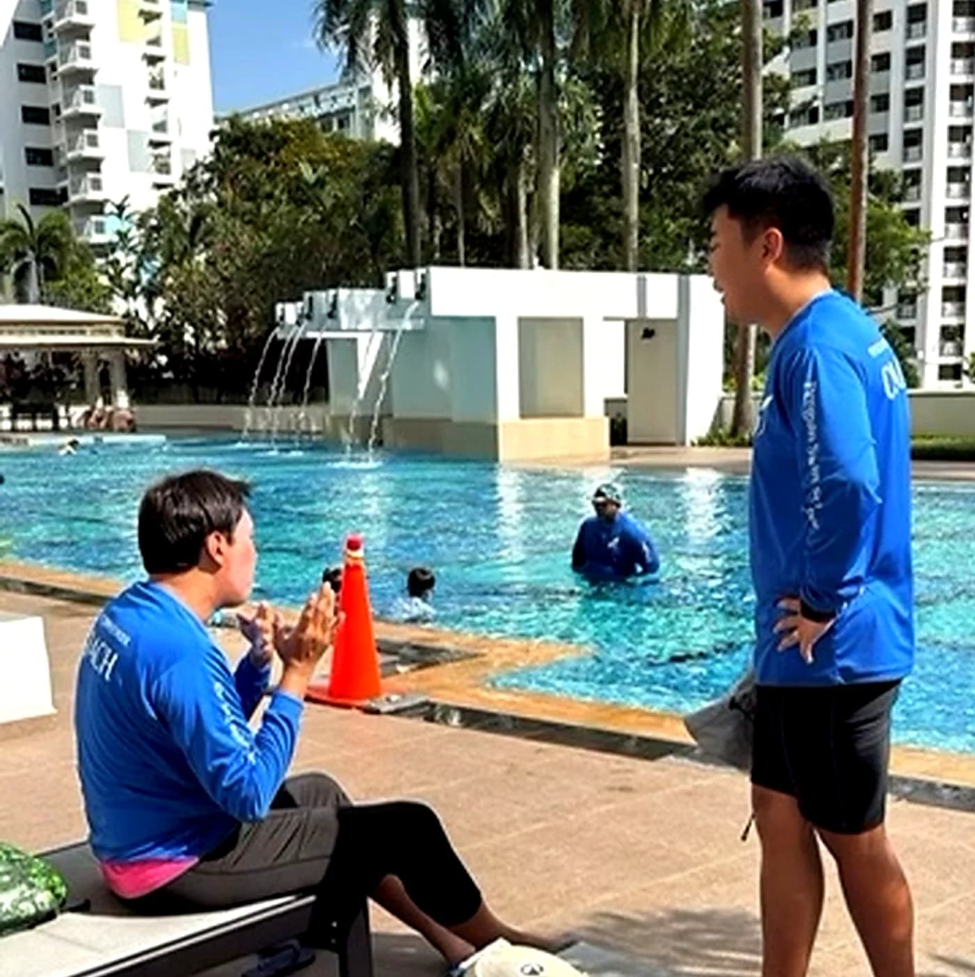 Rayner Teo speaking with Penguin Swim School coaches during a poolside coach briefing