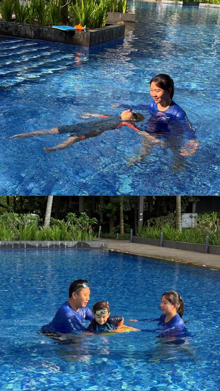 Two swimming coaches supporting a child during an in-pool lesson