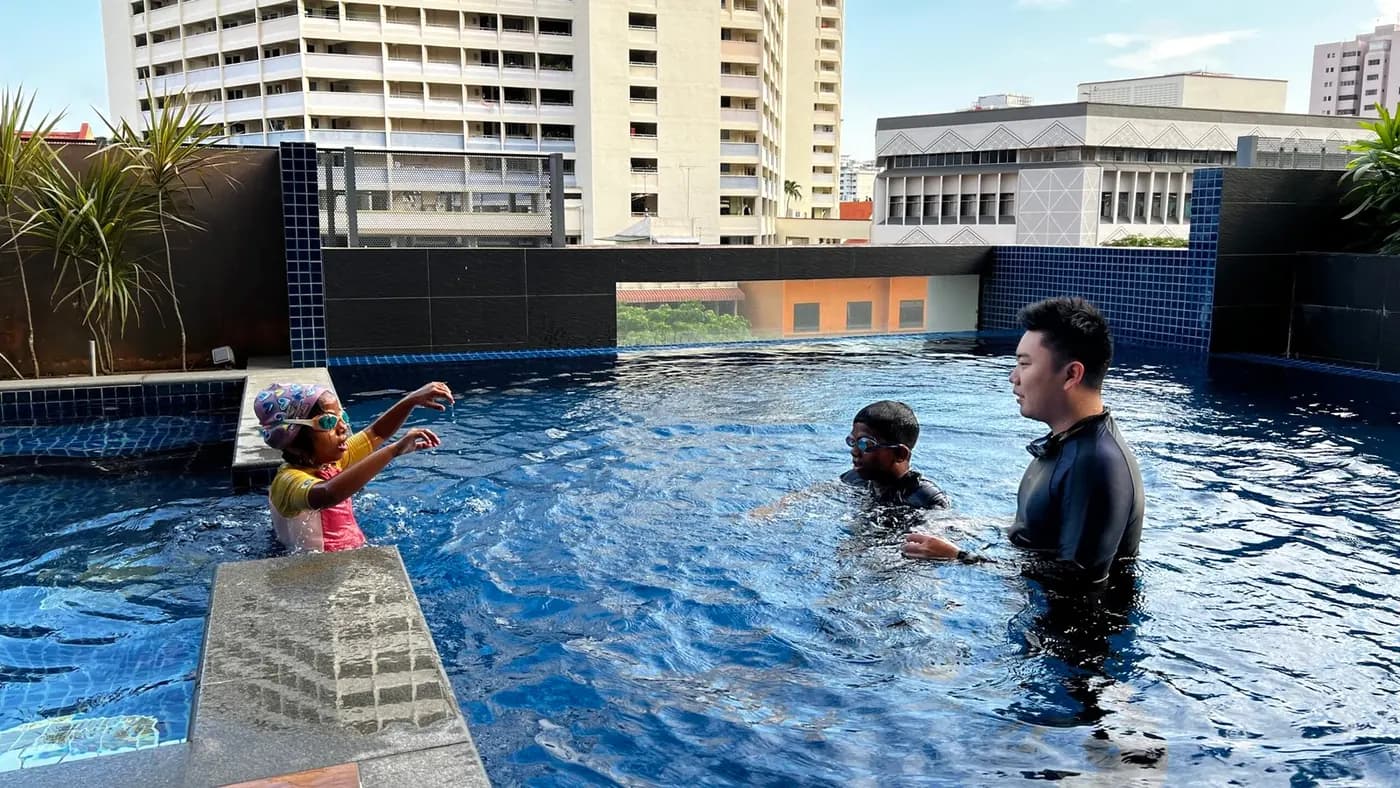 Penguin Swim School coach teaching children during a private swimming lesson at a condo pool
