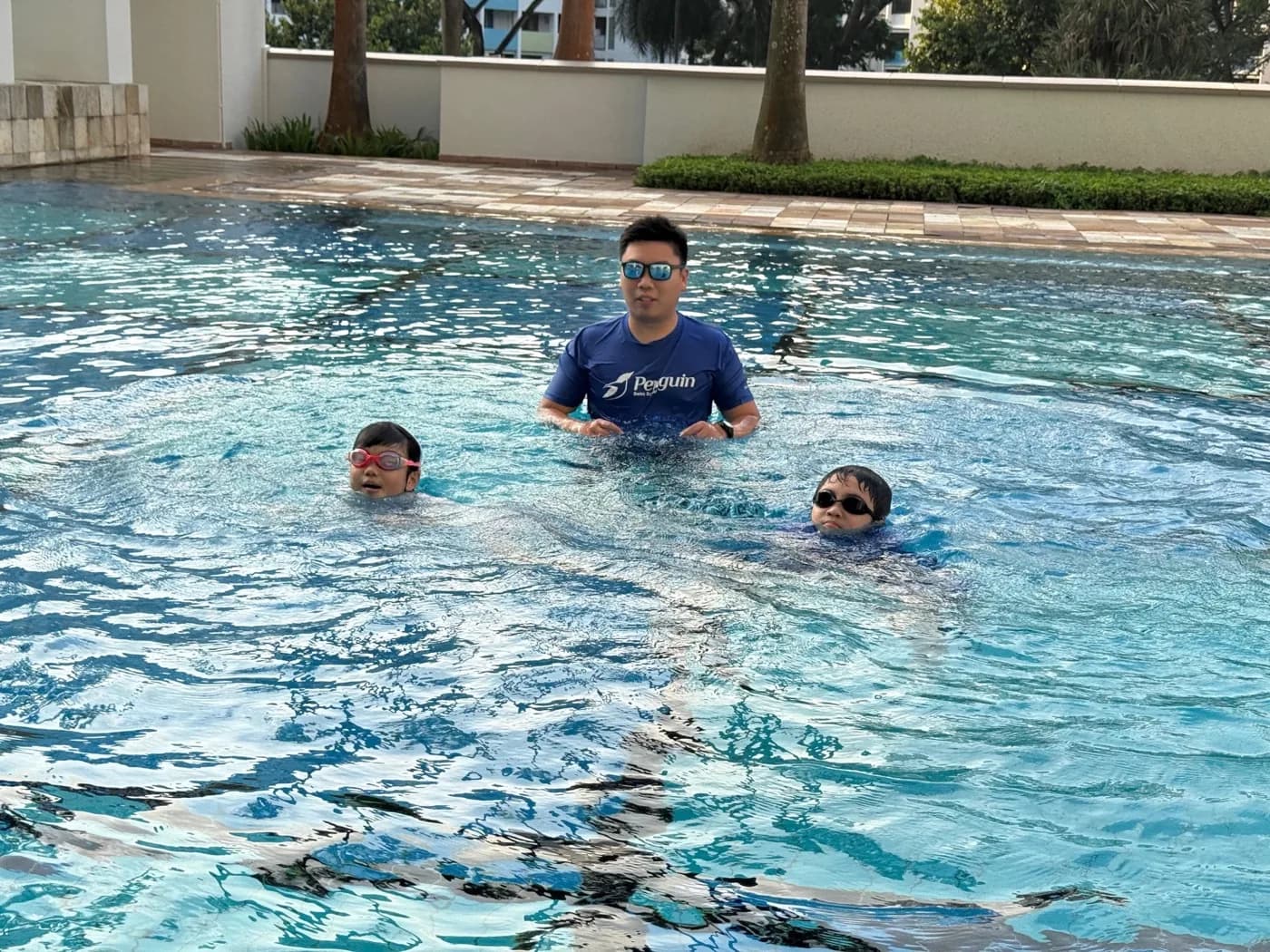Penguin Swim School coach supervising a privately formed group lesson for children