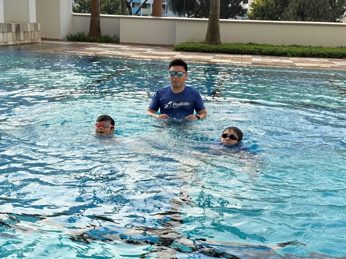 Penguin Swim School coach supervising a privately formed group lesson for children
