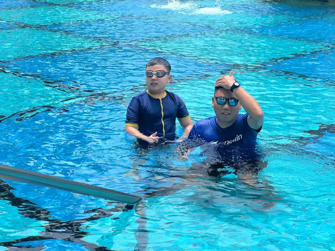 Rayner Teo supporting a child during a Penguin Swim School kids private swimming lesson