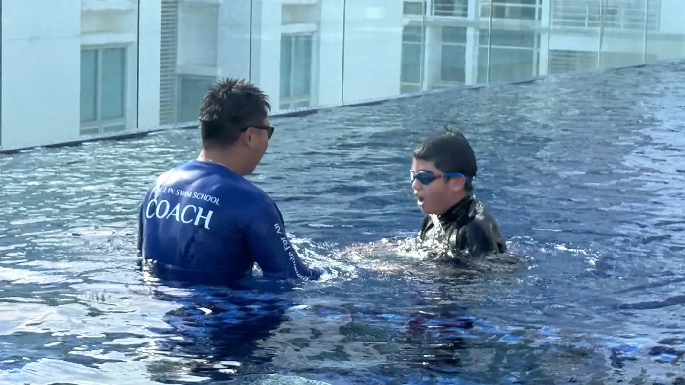 Rayner Teo providing calm one-to-one swimming support to a child during a Penguin Swim School private lesson