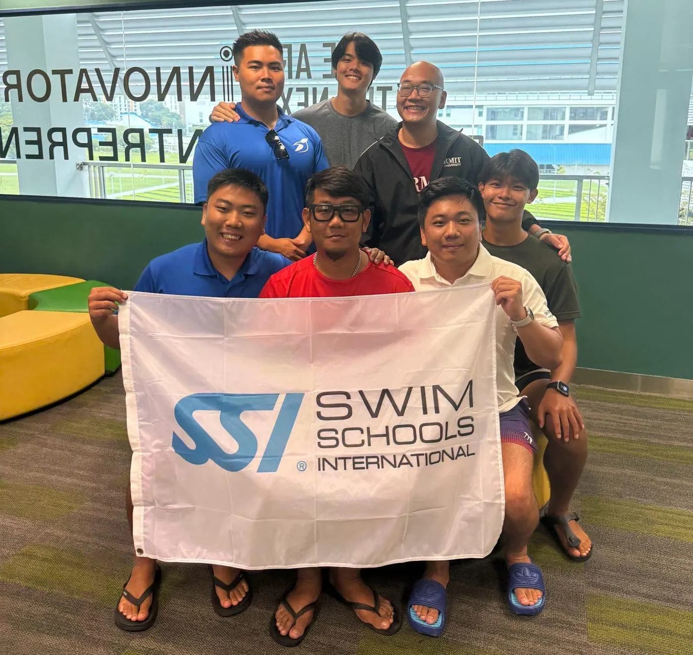 Penguin Academy graduates with SSI Swim Schools International banner