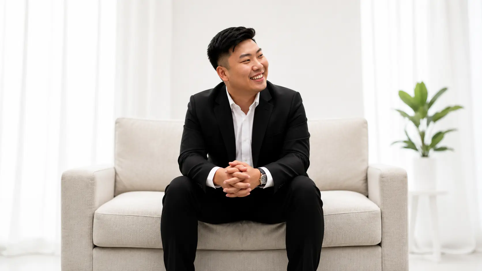 Rayner Teo seated on a light sofa in a bright living room