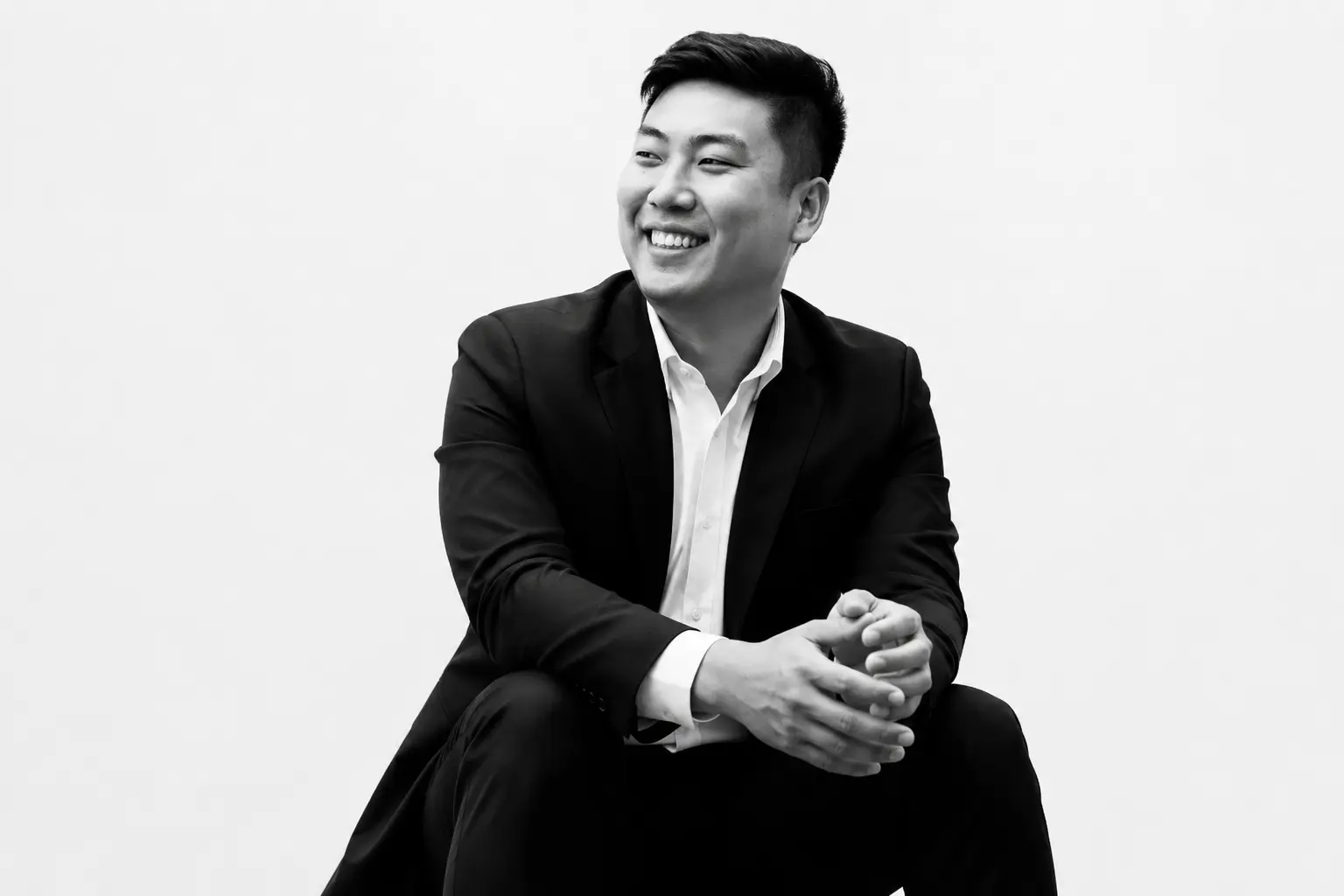 Rayner Teo smiling in a black suit jacket and white shirt